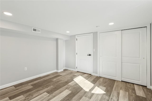 unfurnished bedroom with light wood-type flooring and a closet