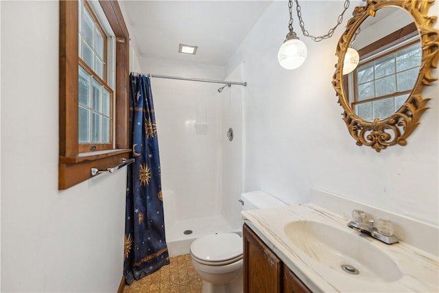 bathroom featuring walk in shower, vanity, and toilet