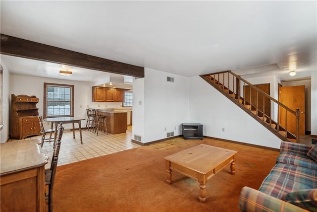 living room featuring beamed ceiling and light colored carpet