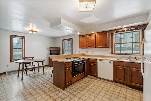 kitchen with sink, white dishwasher, kitchen peninsula, and gas stove