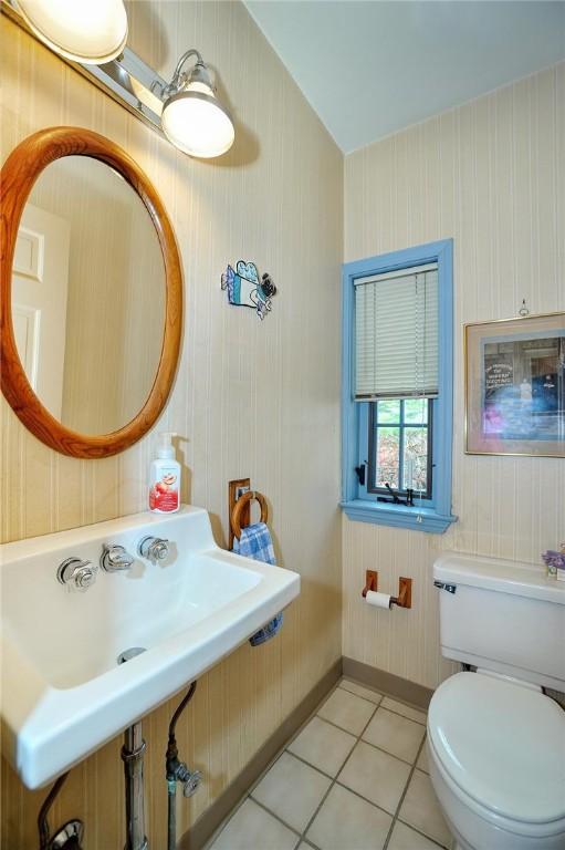 bathroom with tile patterned flooring, toilet, and baseboards