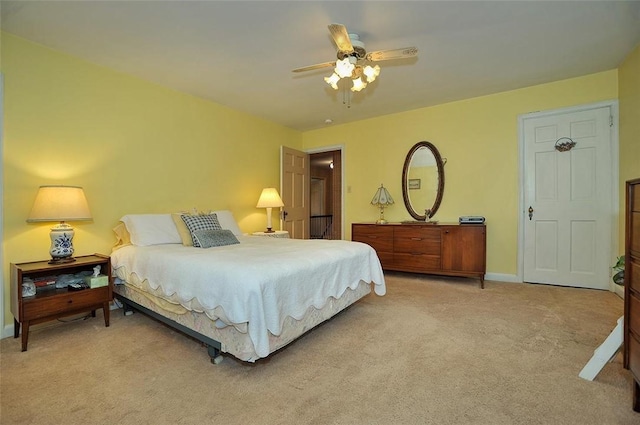 bedroom featuring light carpet, a ceiling fan, and baseboards