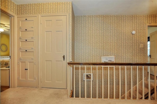 hall with wallpapered walls and carpet