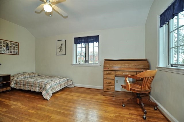 bedroom with multiple windows, baseboards, lofted ceiling, and wood-type flooring