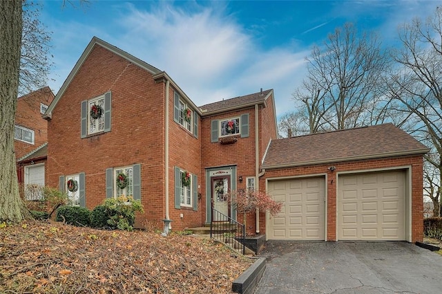 view of front of house featuring entry steps, aphalt driveway, brick siding, and a garage