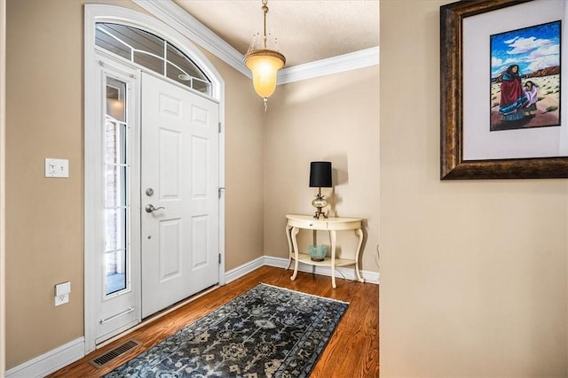 foyer entrance featuring hardwood / wood-style flooring, ornamental molding, and a textured ceiling