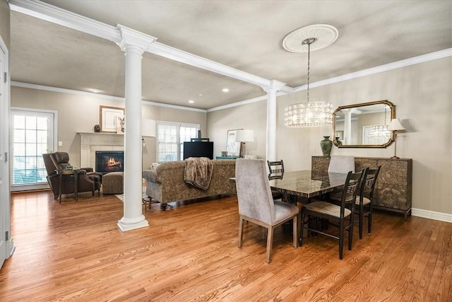 dining area featuring crown molding, hardwood / wood-style floors, and ornate columns