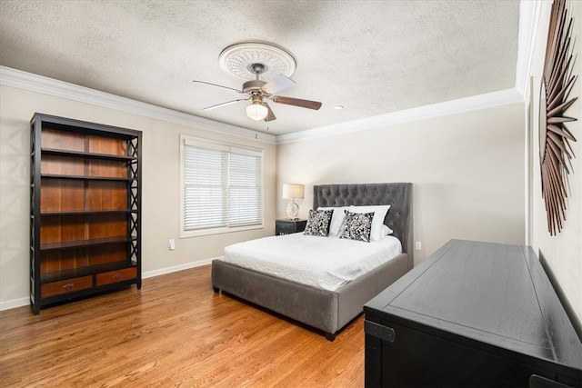 bedroom with crown molding, wood-type flooring, a textured ceiling, and ceiling fan