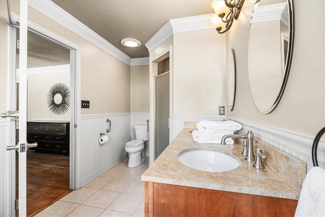 bathroom with vanity, toilet, crown molding, tile patterned floors, and a textured ceiling