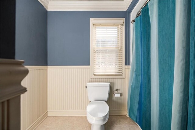 bathroom with ornamental molding, toilet, and tile patterned flooring