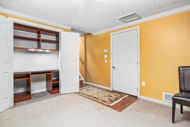 entryway with crown molding, carpet, and a textured ceiling