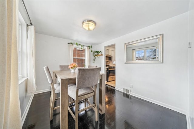 dining space with dark hardwood / wood-style flooring