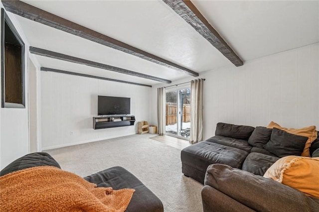 carpeted living room featuring beam ceiling