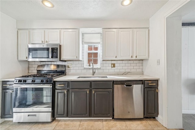 kitchen featuring white cabinetry, appliances with stainless steel finishes, sink, and decorative backsplash