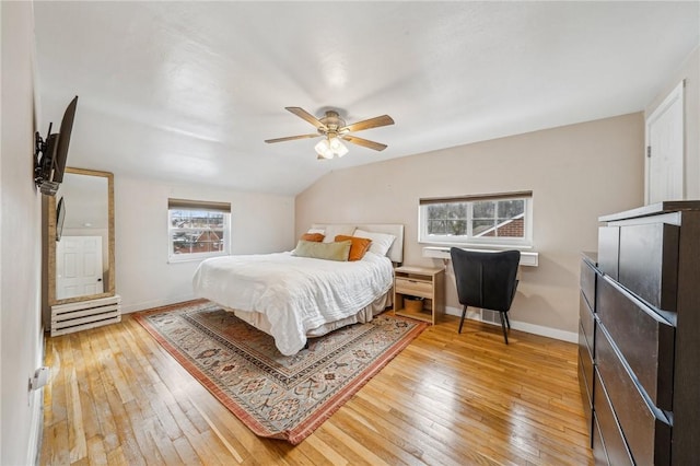 bedroom featuring hardwood / wood-style floors, vaulted ceiling, and ceiling fan