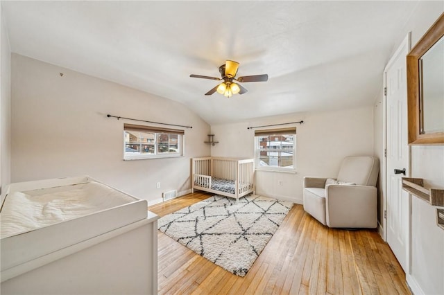 bedroom featuring light hardwood / wood-style flooring, ceiling fan, and vaulted ceiling