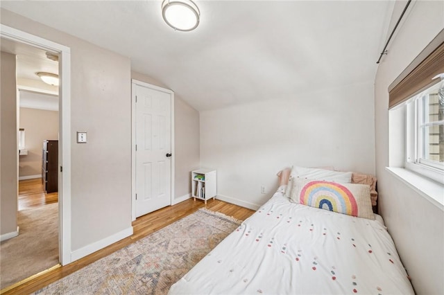 bedroom featuring hardwood / wood-style flooring and vaulted ceiling