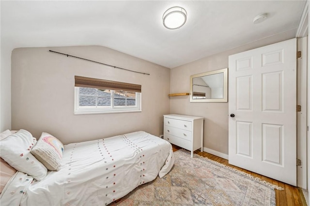 bedroom with vaulted ceiling and wood-type flooring