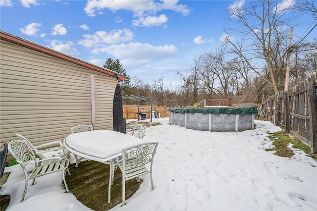 yard layered in snow featuring a pergola and a covered pool