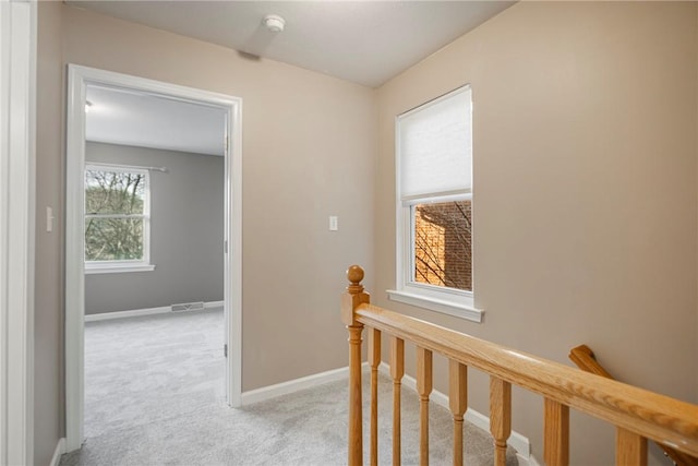 corridor featuring light colored carpet