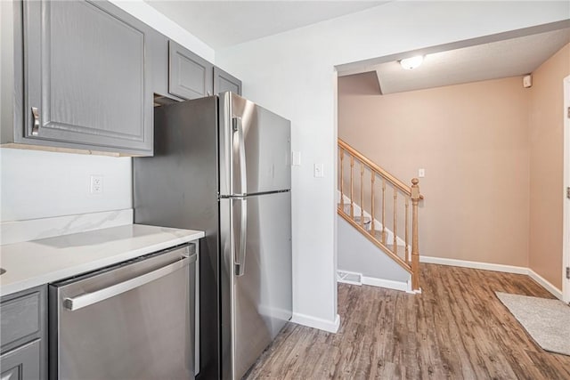 kitchen featuring gray cabinets, light hardwood / wood-style flooring, and stainless steel appliances