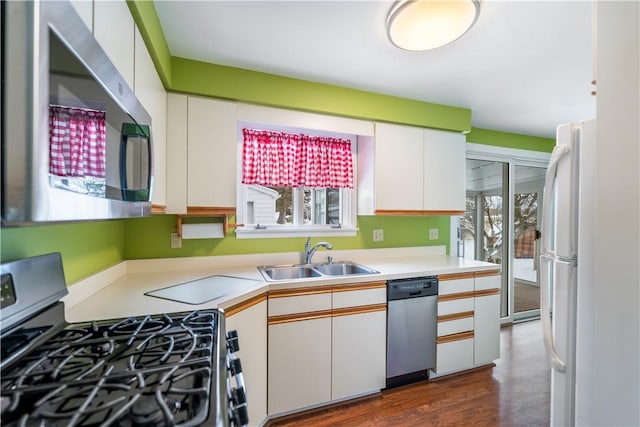 kitchen featuring white cabinetry, appliances with stainless steel finishes, dark hardwood / wood-style flooring, and sink