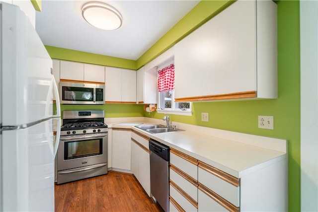 kitchen featuring sink, hardwood / wood-style floors, white cabinets, and appliances with stainless steel finishes