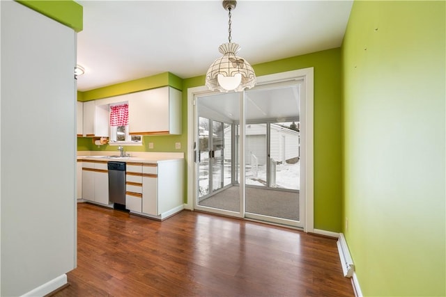 interior space featuring sink, dark wood-type flooring, dishwasher, white cabinetry, and hanging light fixtures