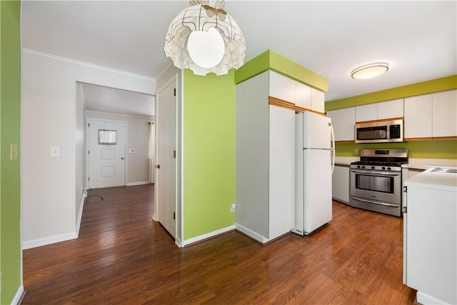 kitchen with white cabinetry, appliances with stainless steel finishes, dark hardwood / wood-style floors, and decorative light fixtures