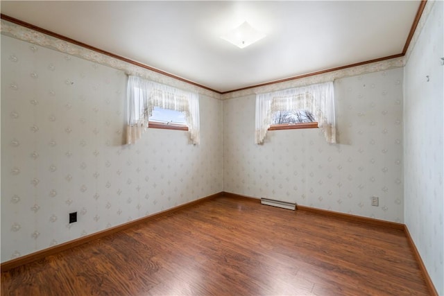 spare room featuring crown molding and wood-type flooring