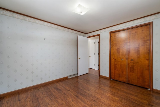 unfurnished bedroom with a closet, crown molding, and dark hardwood / wood-style floors