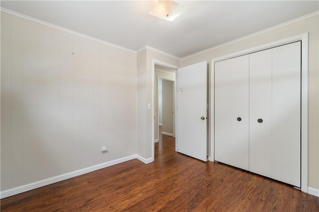 unfurnished bedroom with crown molding, dark wood-type flooring, and a closet