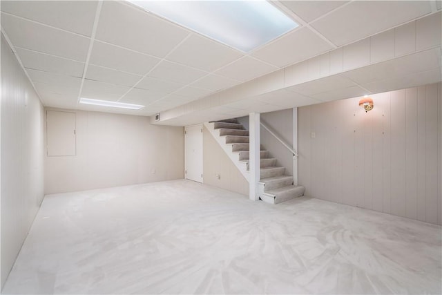 basement featuring a drop ceiling and carpet floors