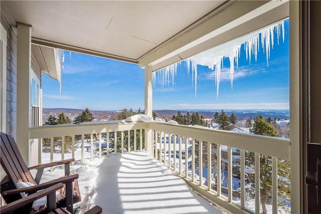 view of snow covered back of property