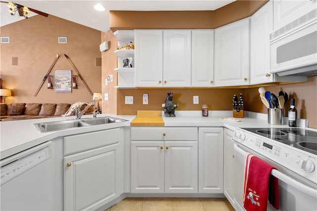 kitchen featuring sink, white appliances, light tile patterned floors, and white cabinets