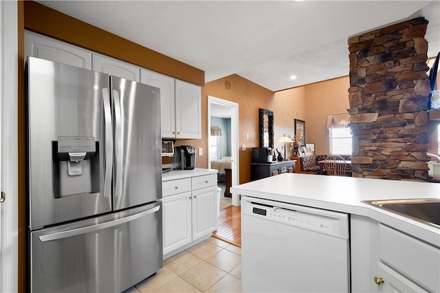 kitchen featuring stainless steel refrigerator with ice dispenser, dishwasher, light tile patterned floors, and white cabinets