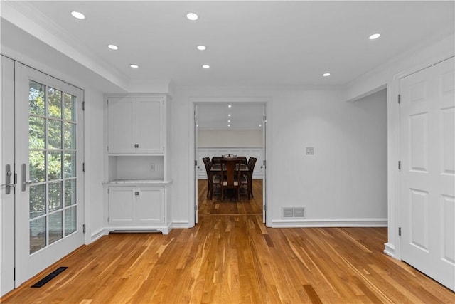 interior space with crown molding and light wood-type flooring