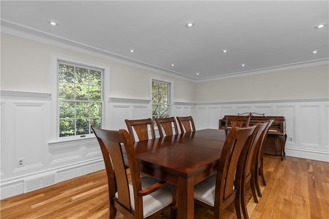 dining area with light hardwood / wood-style flooring and ornamental molding