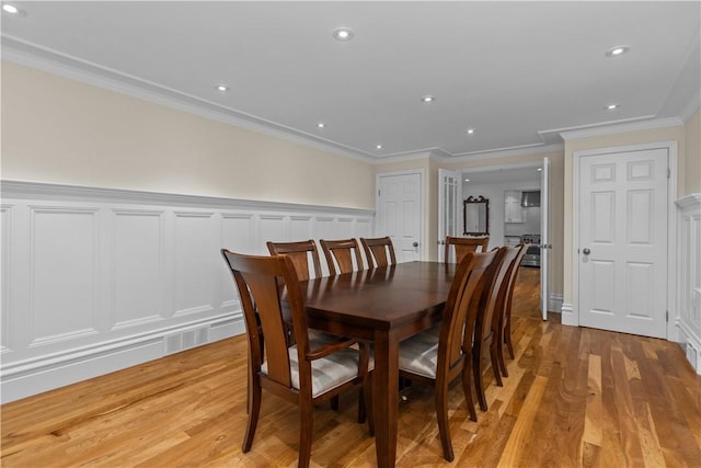 dining room featuring ornamental molding and light hardwood / wood-style floors