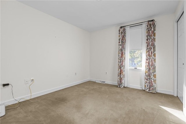 unfurnished room with light carpet