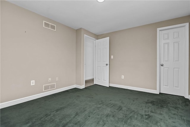 spare room with dark colored carpet