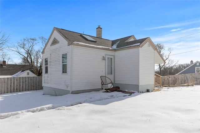 view of snow covered back of property