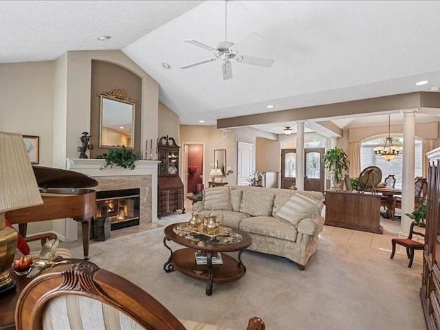 living room with ceiling fan with notable chandelier, light colored carpet, a premium fireplace, and ornate columns