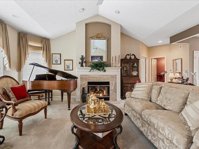 interior space with light carpet, a tiled fireplace, and vaulted ceiling