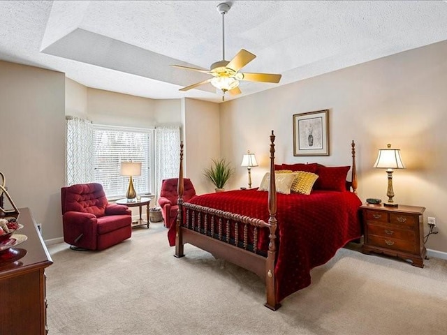 carpeted bedroom featuring ceiling fan and a textured ceiling