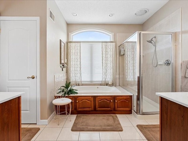 bathroom with vanity, a textured ceiling, tile patterned floors, and separate shower and tub