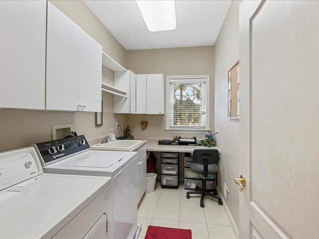 laundry room featuring sink, washer and clothes dryer, cabinets, a textured ceiling, and light tile patterned flooring