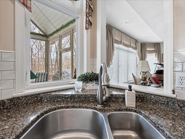 kitchen featuring dark stone countertops and sink