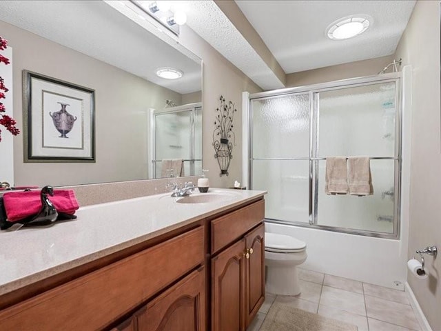 full bathroom featuring vanity, combined bath / shower with glass door, tile patterned floors, and toilet