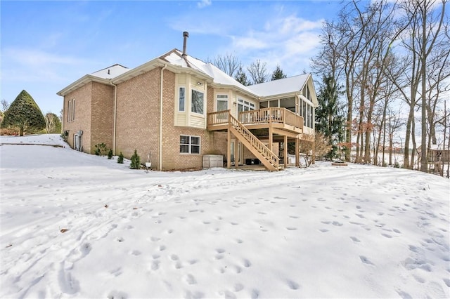 snow covered property with a deck